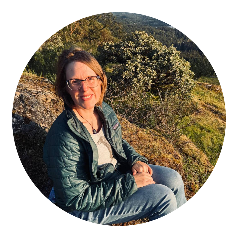 Anne-Lynn sitting on a hillside overlooking a lake